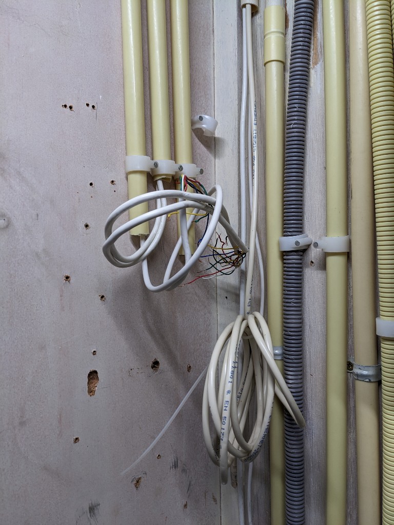 Foto van loshangende kabels die voorheen werden gebruikt voor alarmsysteem en telefonie.