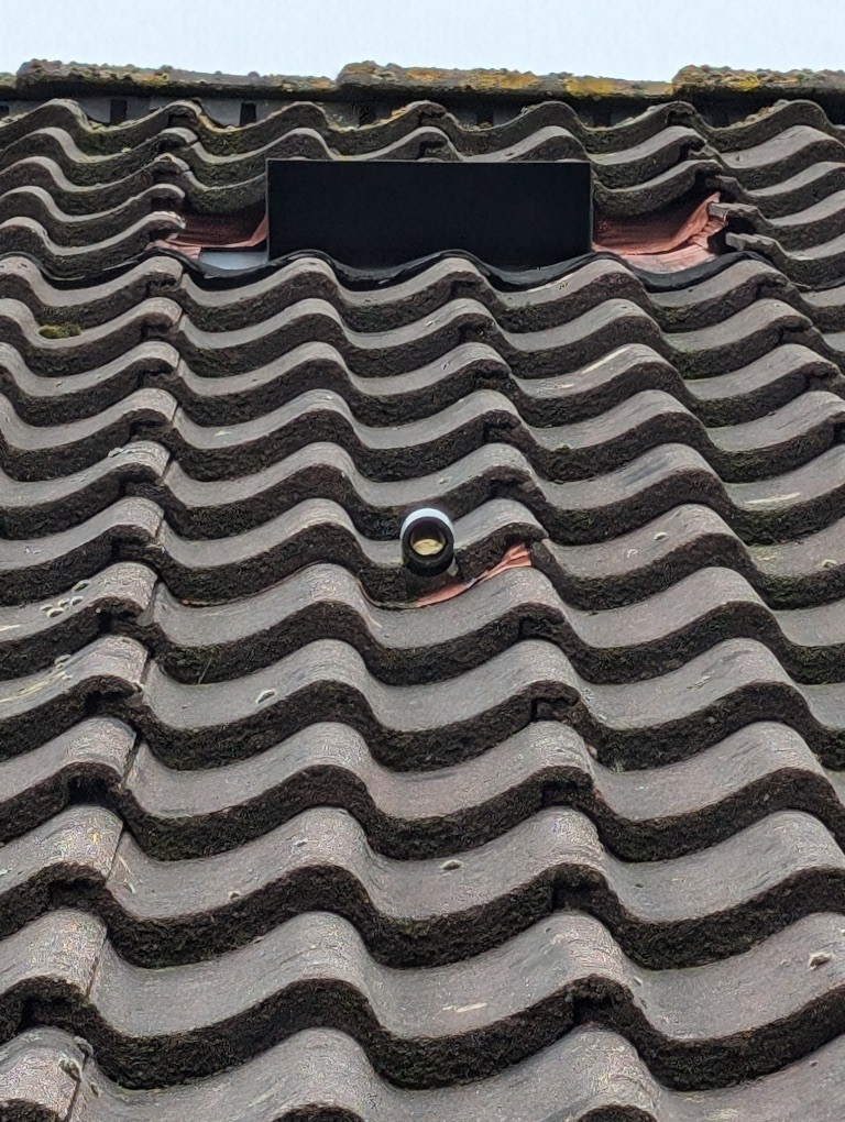 Foto van dak waarop condensafvoer zichtbaar is met daarboven een dakdoorvoer ten behoeve van de uitblaas